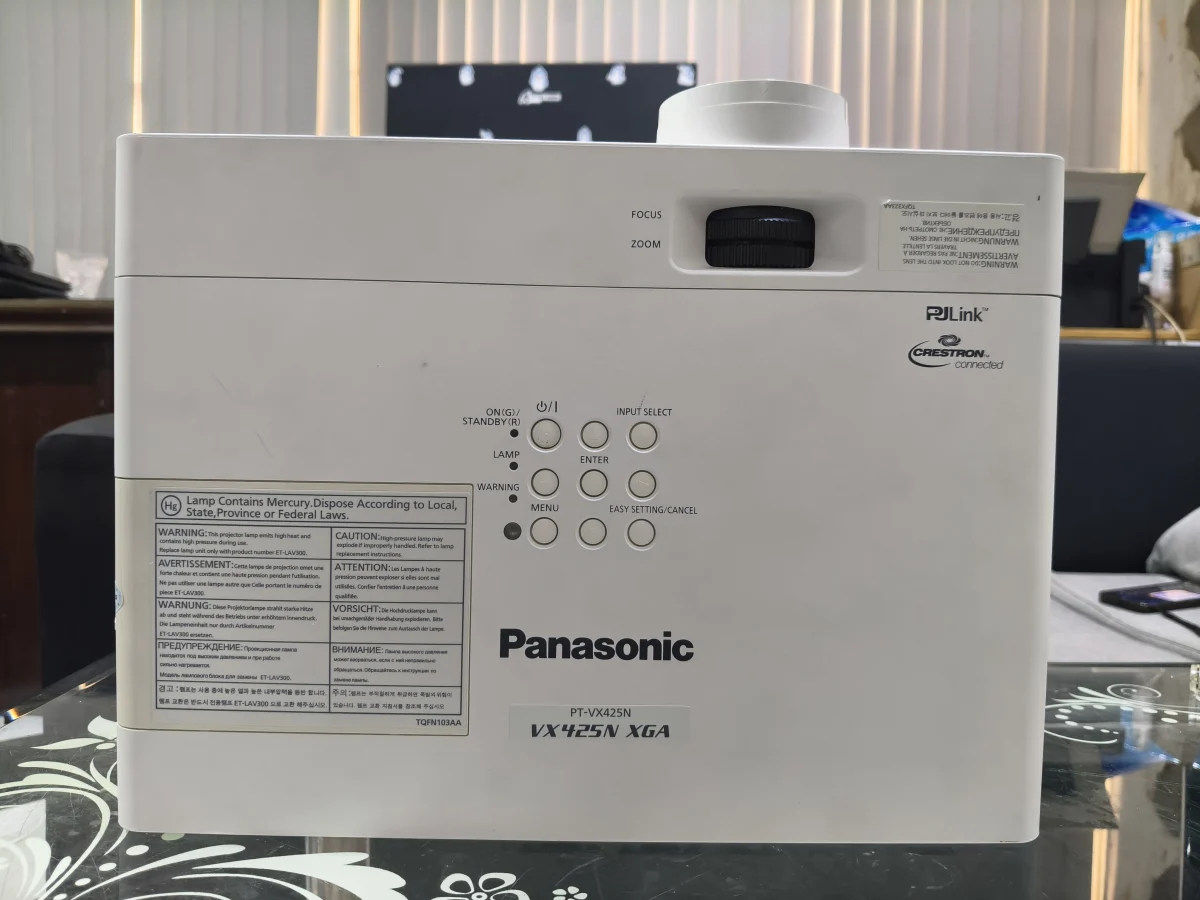 Mặt trên Panasonic PT-VX425N với nhãn VX425N XGA, núm zoom/focus và bảng phím - ảnh máy thật
