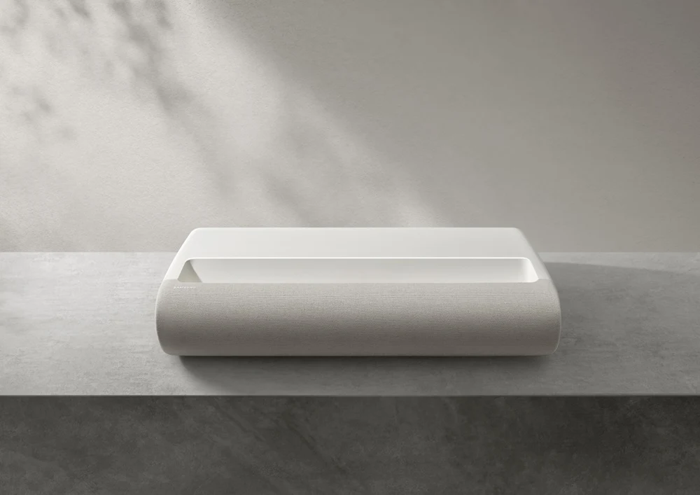 Máy chiếu Samsung The Premiere 7 thiết kế UST mỏng đặt trên kệ tủ, vỏ vải màu trắng kem