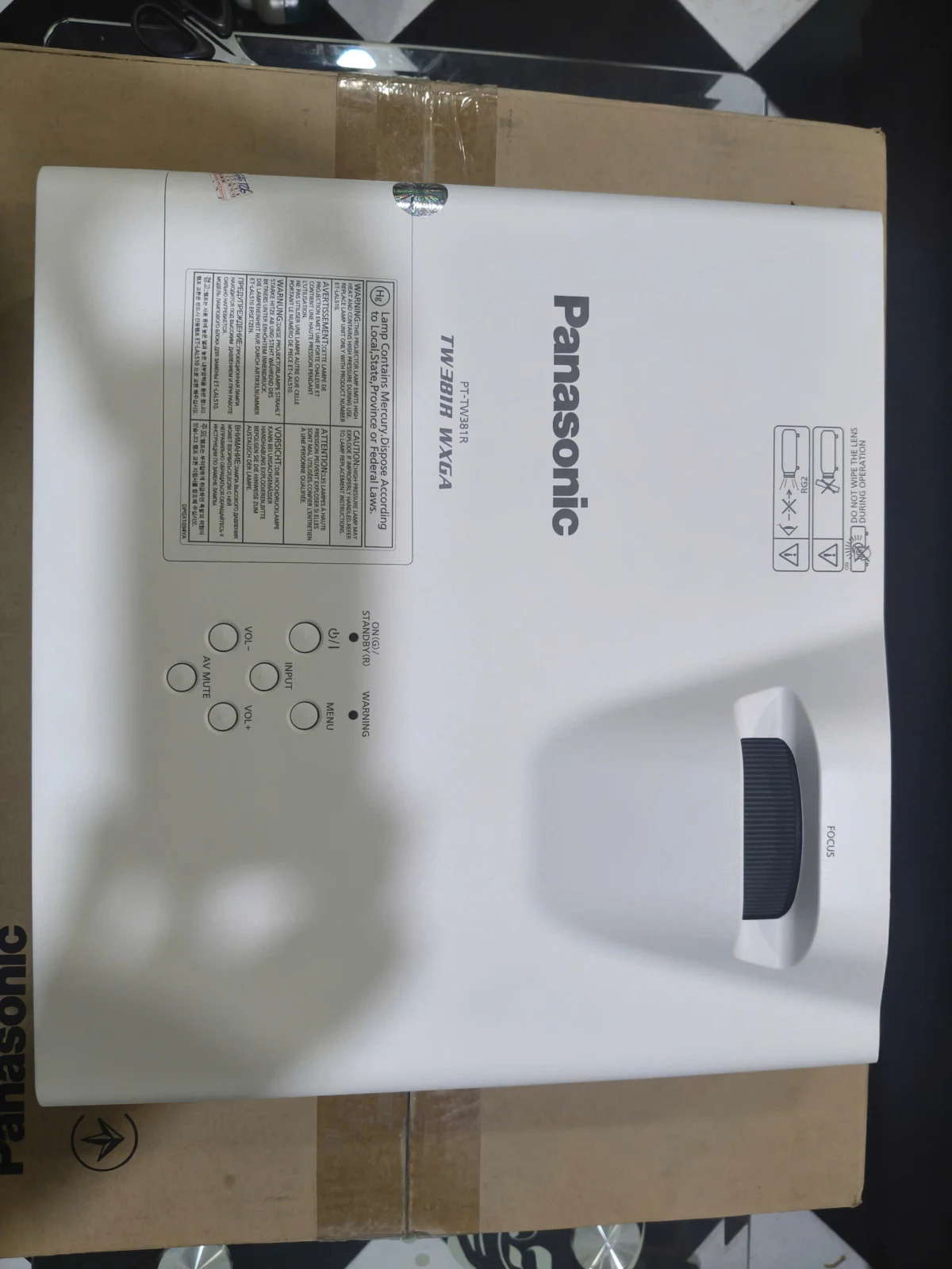 Mặt trên Panasonic PT-TW381R - nhãn model WXGA + bảng điều khiển + vòng lấy nét Mặt trên Panasonic PT-TW381R - nhãn model WXGA + bảng điều khiển + vòng lấy nét