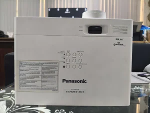 Mặt trên Panasonic PT-VX425N với nhãn VX425N XGA, núm zoom/focus và bảng phím - ảnh máy thật